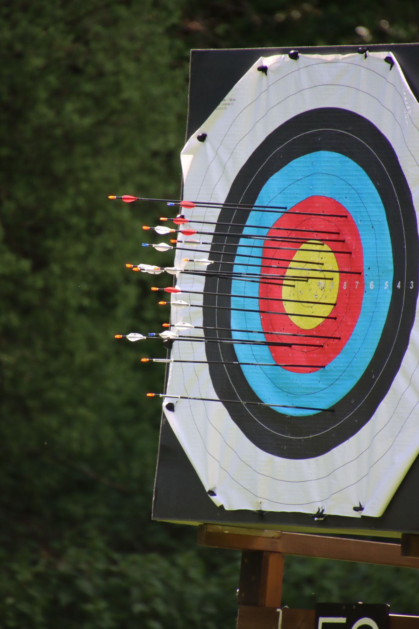 A paper face on a timber stand with arrows waiting alongside it