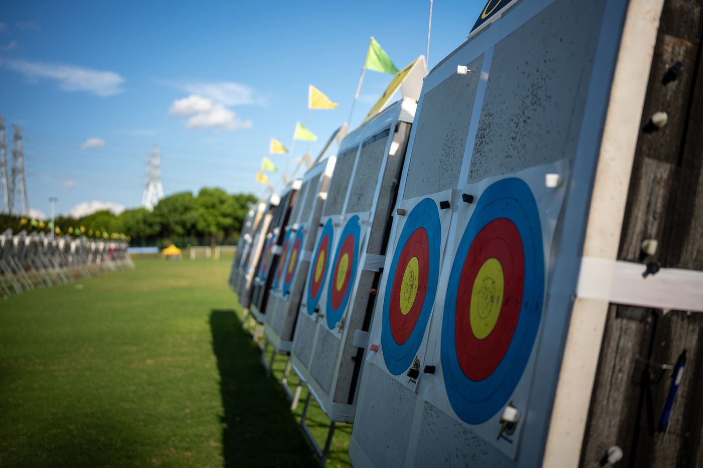 A line of archers shooting down a grass range toward distant targets
