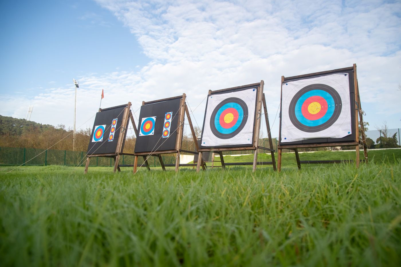 Four target butts on timber stands in long grass, set out under a wide sky